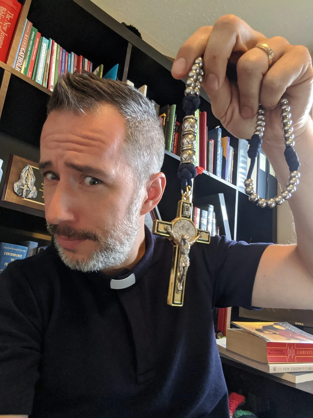 Deacon Ryan Sales holding a large rosary and crucifix